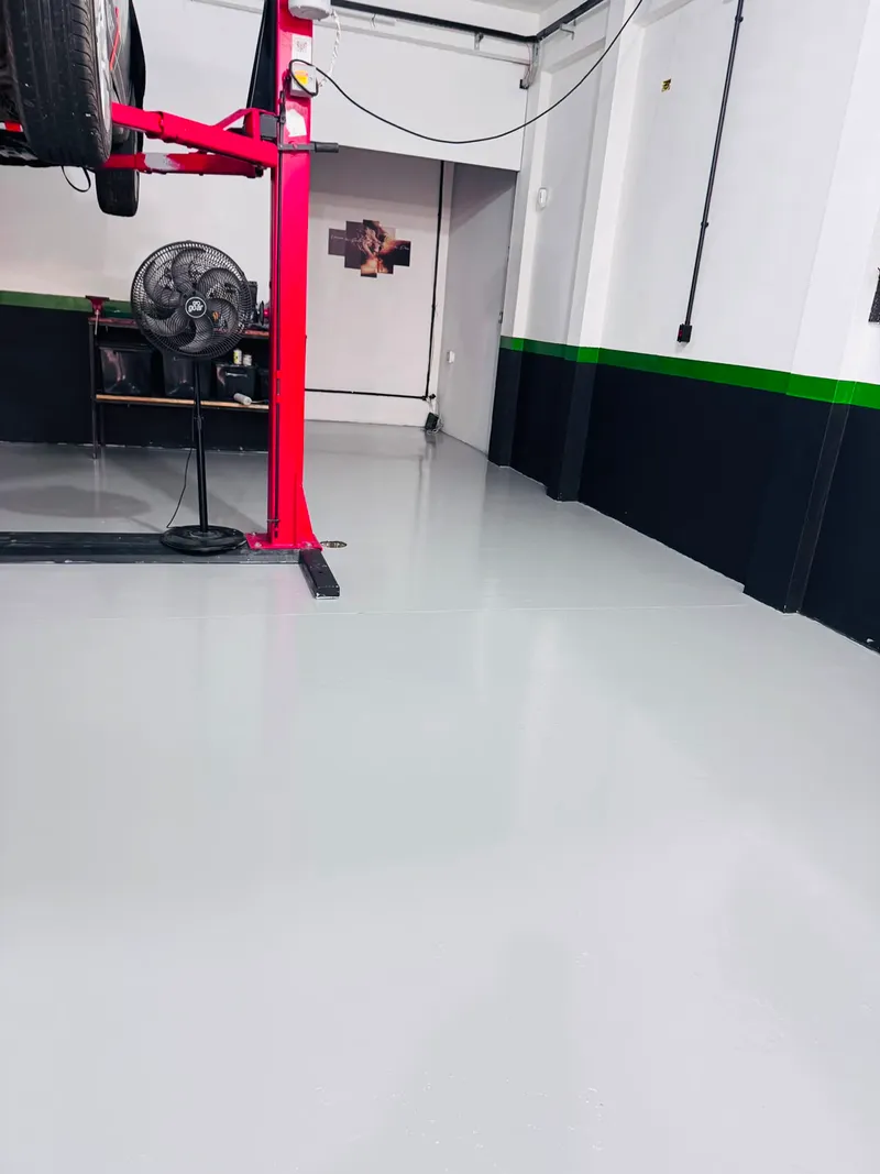 Corredor da oficina DM Garage com elevador e piso limpo e organizado