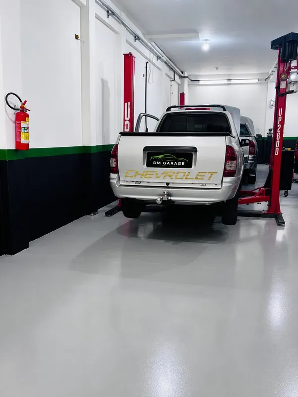 Picape sendo erguida em elevador profissional na oficina DM Garage